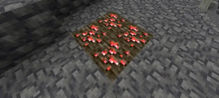 Glowing red ore embedded in stone ground