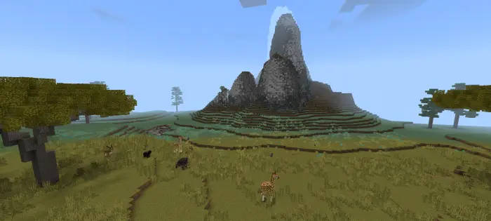 Giraffes and animals roam a grassy savanna.