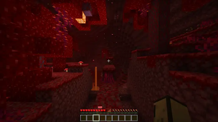 Player navigating a narrow path in the Nether