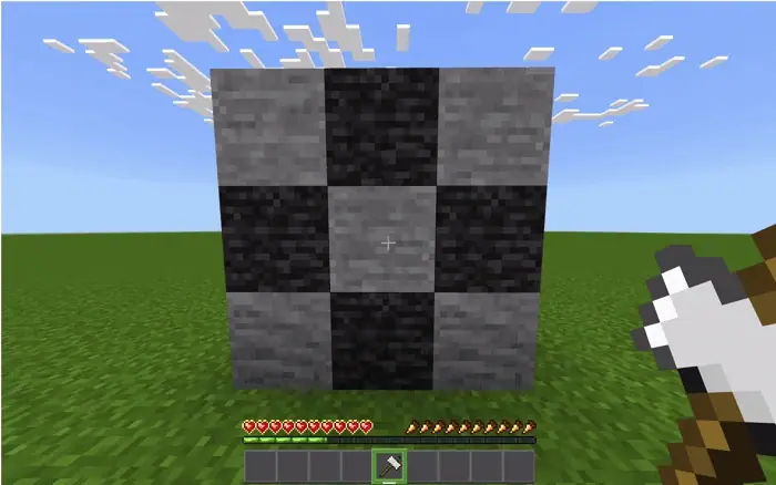 Axe held before a checkered stone wall.