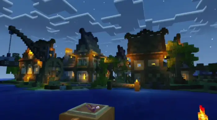 Village at night with glowing lights and water