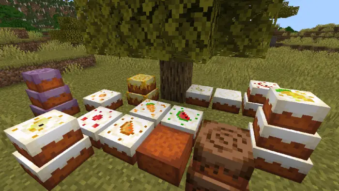 Various decorated cakes displayed under a tree