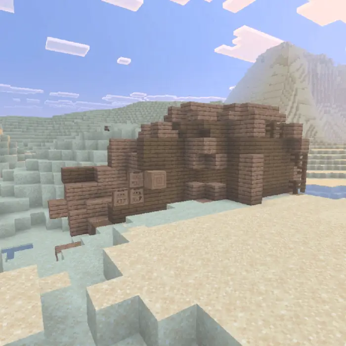 Wooden shipwreck on a sandy beach.