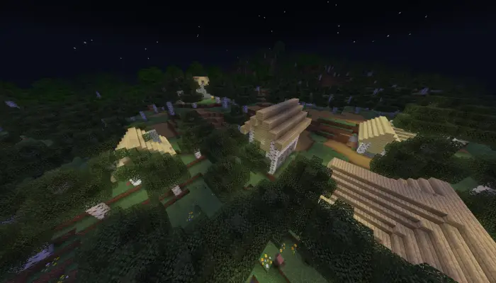 Village houses nestled in a forest at night