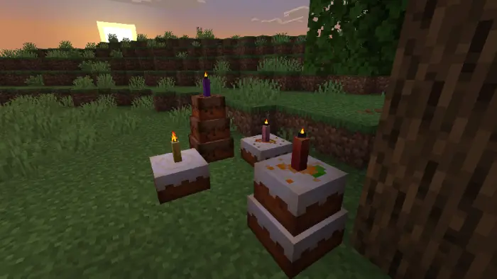 Multiple cakes with candles in grassy area