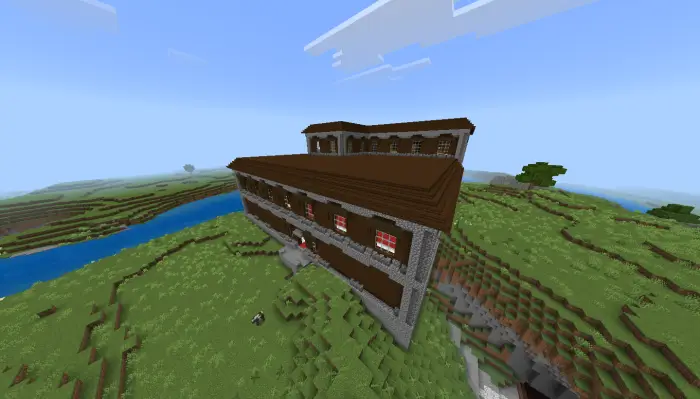 Large mansion on grassy plains by a river