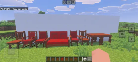 Wooden chairs, tables, and a red sofa outdoors