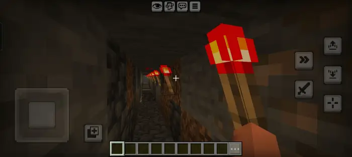 Dark tunnel lit by red torches, eerie vibes