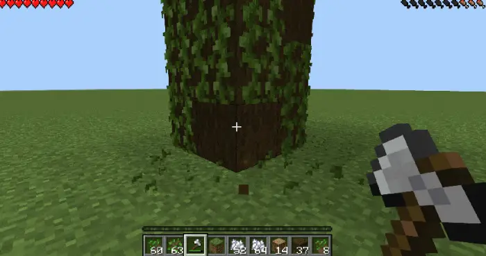 Player chops tree with an axe in-game.