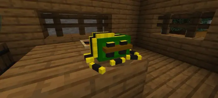Green and yellow pixel frog on wooden table