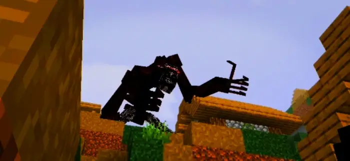 Giant black monster crawling over village.