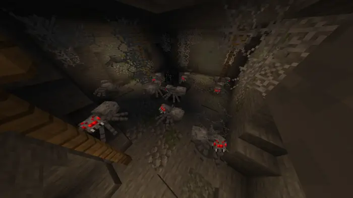 Spiders with glowing red eyes in a dark cave