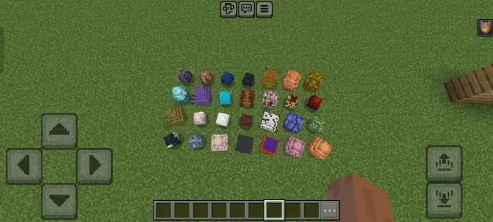 Various colorful saddles and gear on grass.