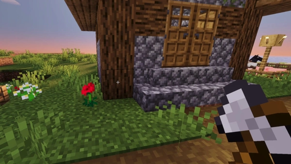 First-person view holding an axe near a cottage