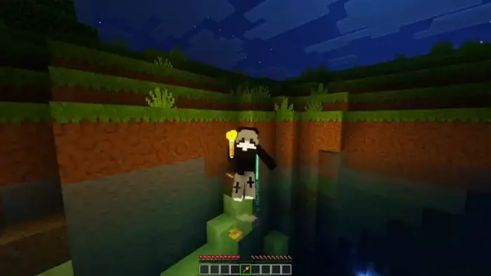 Character holding glowing item by water at night