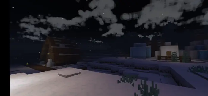 Snowy village at night under cloudy sky