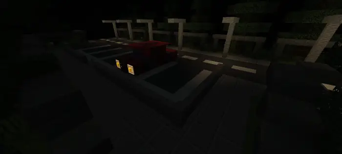 Dark road with parked red car at night.