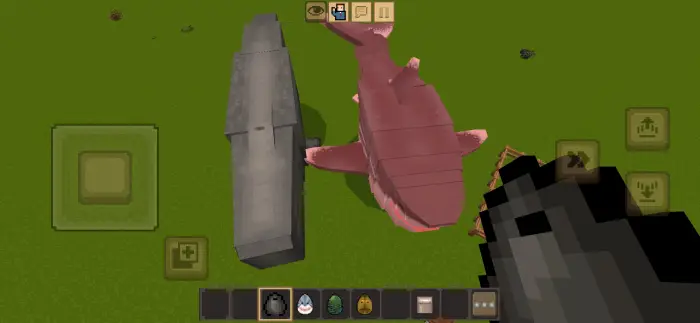 Blocky whale and shark on green terrain.