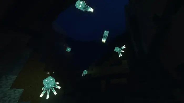 Glowing sea creatures light up a dark cave.
