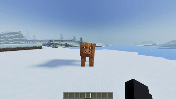 Blocky cow stands on snowy landscape.