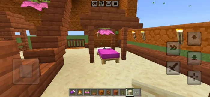 Pink bed under wooden canopy with lanterns