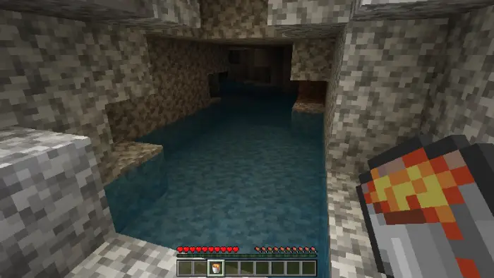 Player holds light source in dark cave.