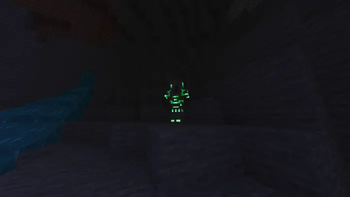 Player with glowing green armor in a dark cave