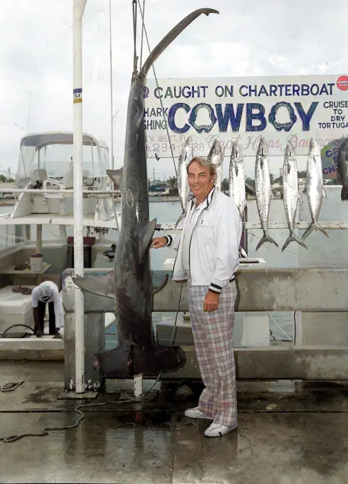 Person posing with a large hammerhead shark