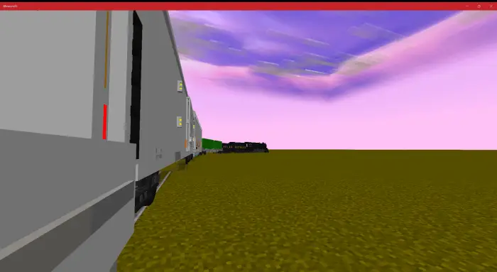 Cargo train cars on open grassy terrain.