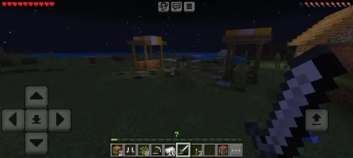 Dark village scene with sword held at night