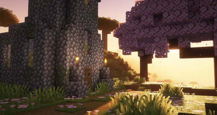 Stone house and pink tree at sunset