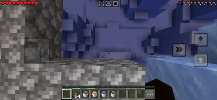 Player looks down icy cave with stone blocks
