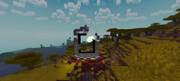 Ruined portal on savanna hillside at sunset