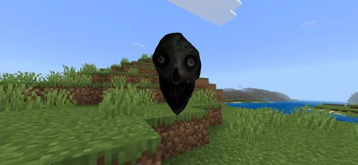 Terrifying black face floating on grassy hill