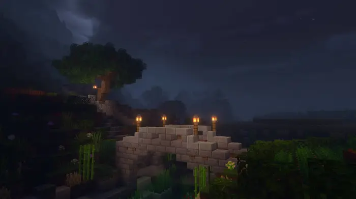 Stone bridge lit by lanterns on a misty night